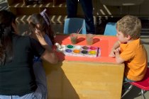 Timothy waits while Darlene paints someone else's face
