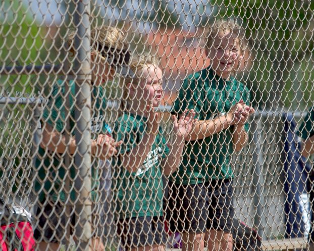 Lindsay, Annie, and Nicole cheer from the dugout