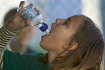 Sophia drinks some water in the dugout