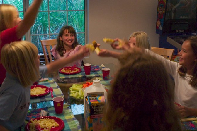 The girls toast each other (with real toast) at dinner