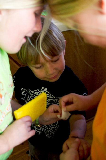 Sara and Lee help Casey peel the paper from his tattoo