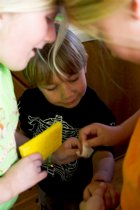 Sara and Lee help Casey peel the paper from his tattoo