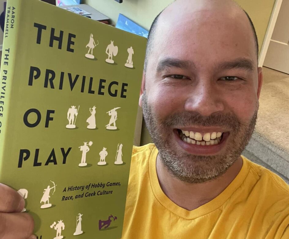 Aaron Trammell holding his book The Privilege of Play