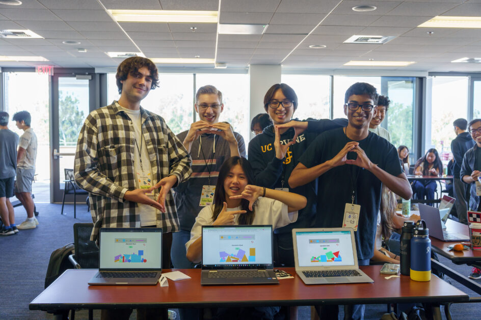 Geometric Rush members behind a laptop displaying their project, each making a geometric shape with their hands.