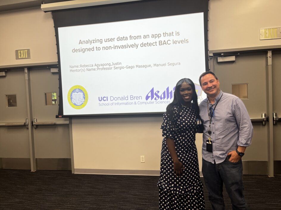 Rebecca Agyapong and Sergio Gago-Masague stand in front of a screen that says “Analyzing user data from an app that is designed to non-invasively detect BAC levels.