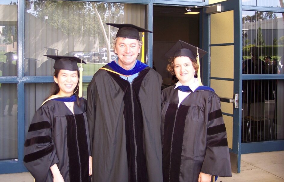Darya, Padhraic, and Se-Young in their black cap and gown outfit.