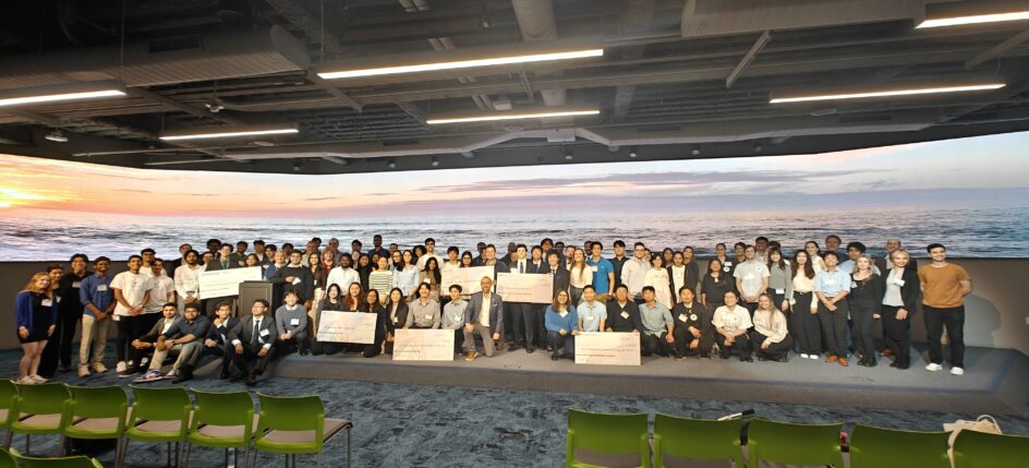 A large group of people, some holding oversized checks.