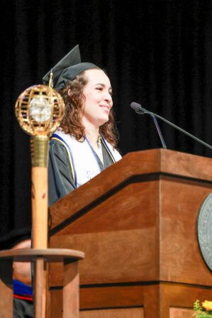 Grace at the podium, speaking during graduation