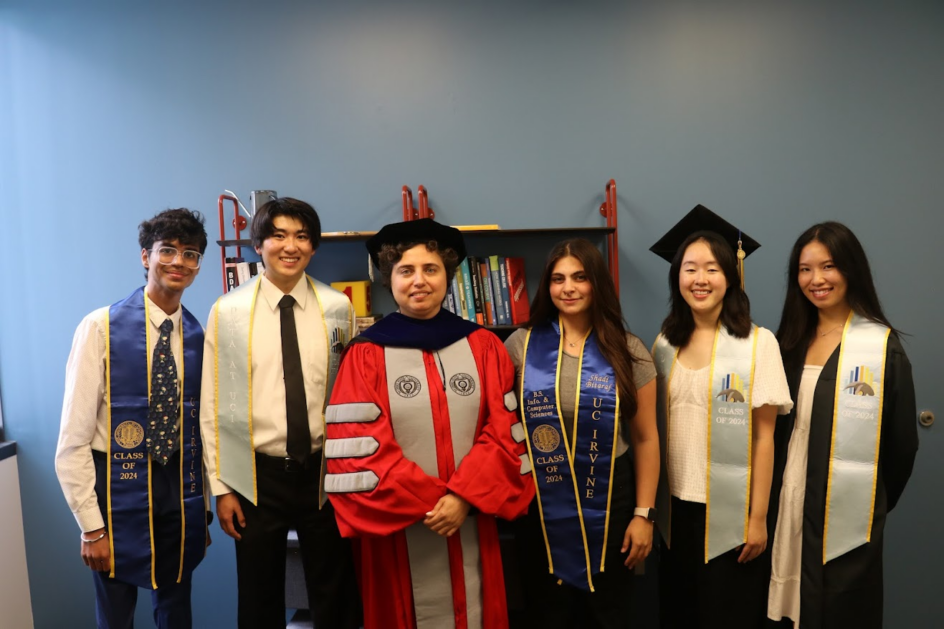 Five students stand around Professor Dogucu