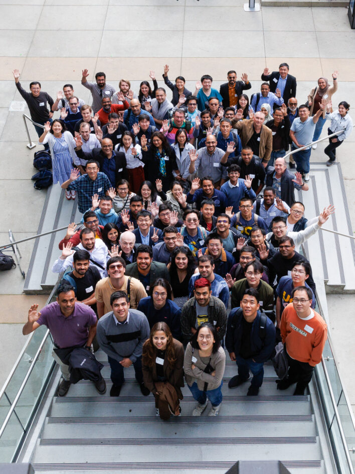 A group photo taken from above, with people waving at the camera