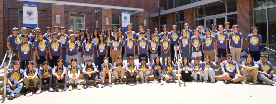 Large group of students outside at UC Irvine, wearing ICS Summer Academy t-shirts