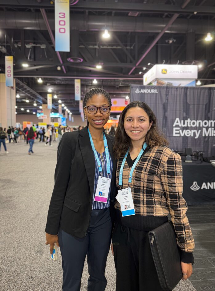 Two students stand together at the conference.